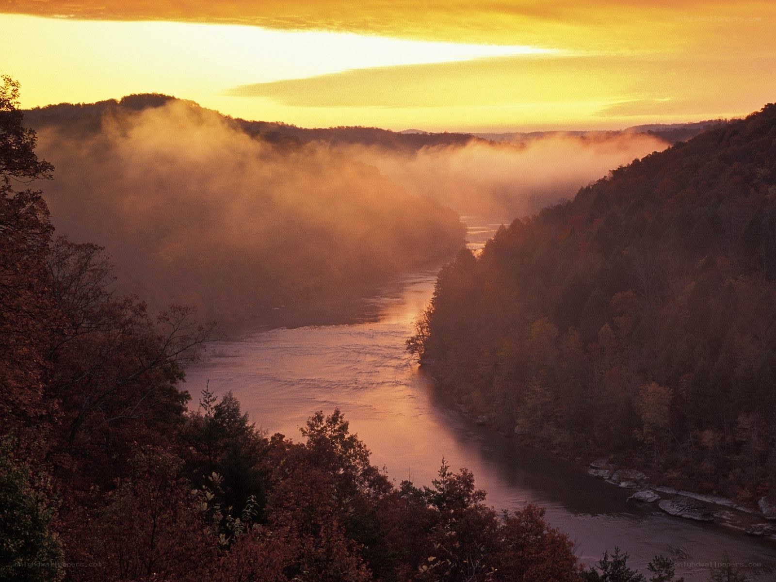 River valley at sunrise with mist