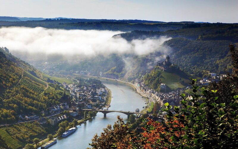 River valley with castle and fog