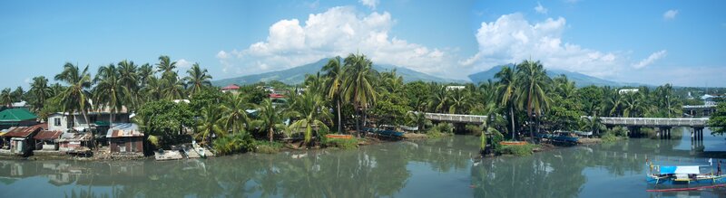 River village with palm trees and mountains