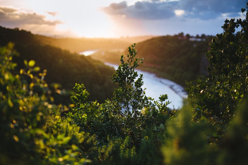 River Winding Through Hills — Green, Serene, Sunset