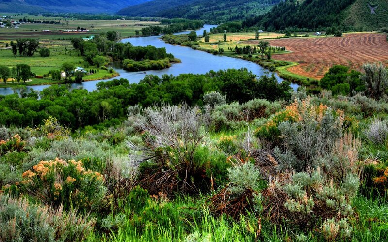 River Winding Through Valley — Green, Serene, Afternoon, Photograph, Trees, Fields, Mountains