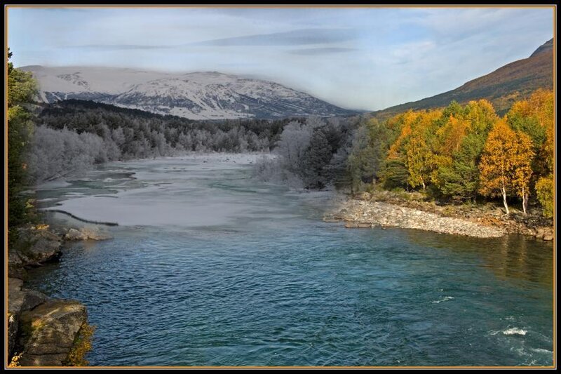 River with autumn trees and snow-capped mountains