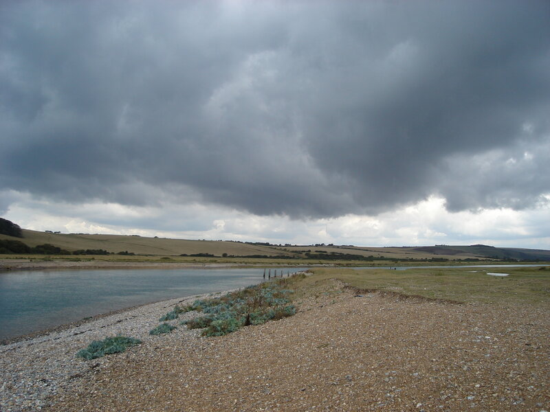 Riverbank under Storm Clouds