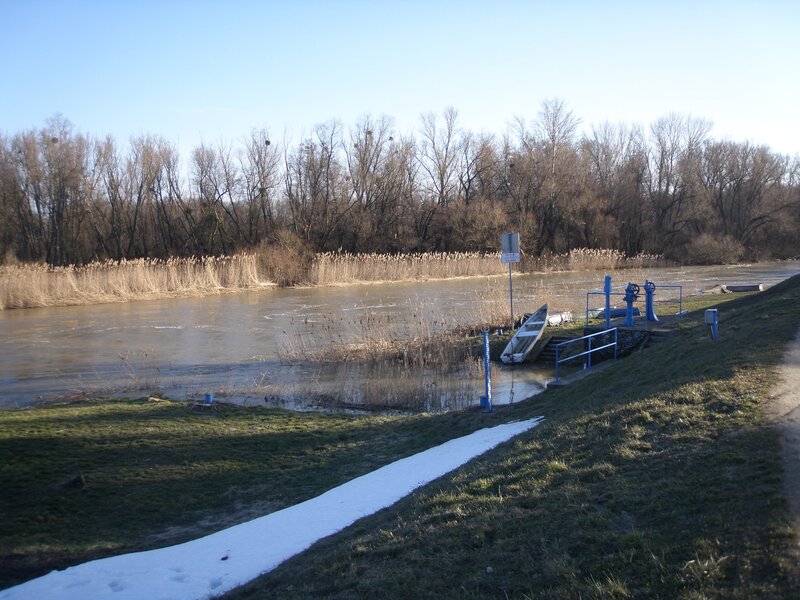 Riverbank with snow and boat