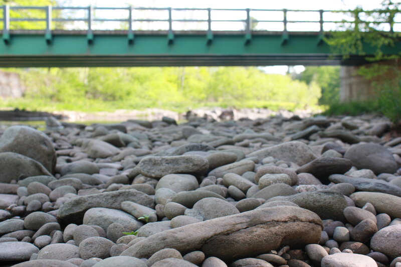 Riverbed under a green bridge