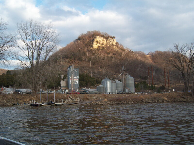 riverfront with silos and hill