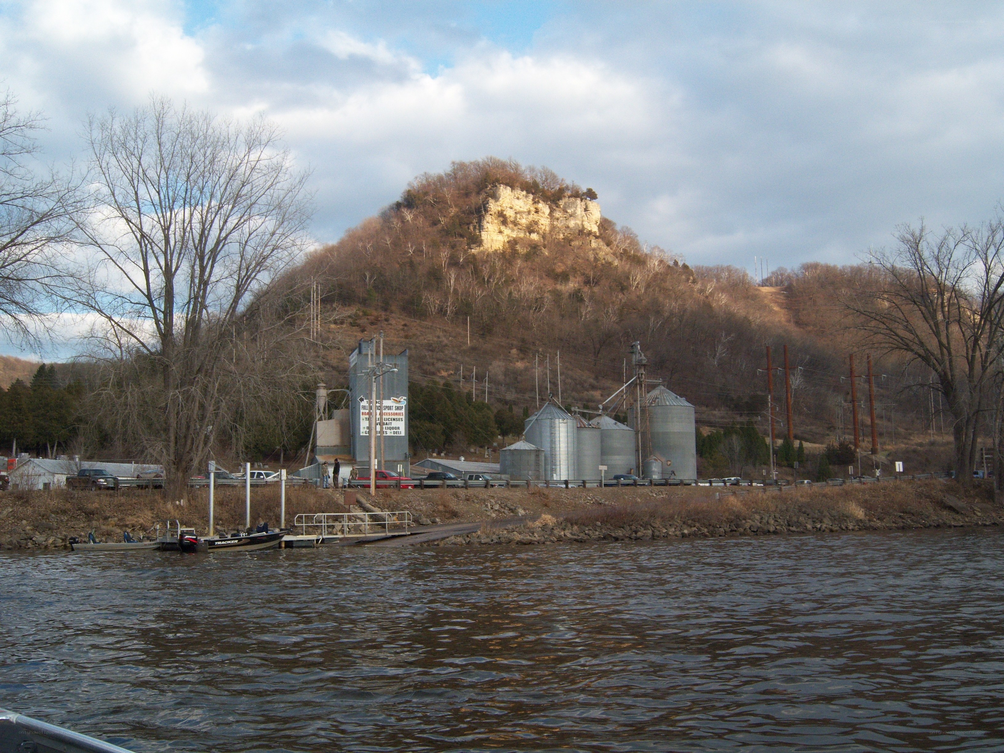 riverfront with silos and hill
