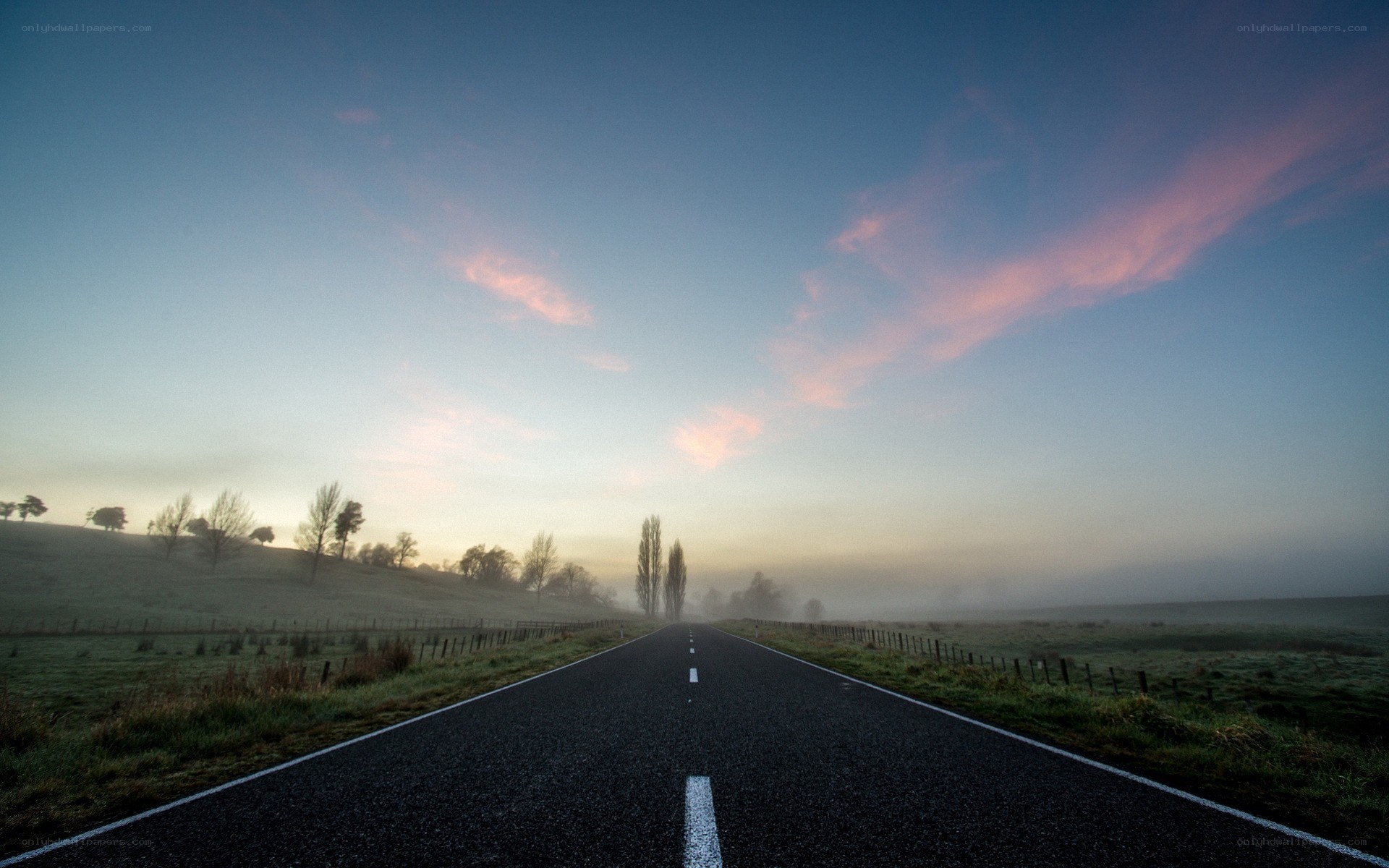 Road at dawn with misty sky