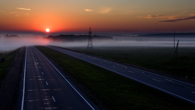 Road at sunrise with fog