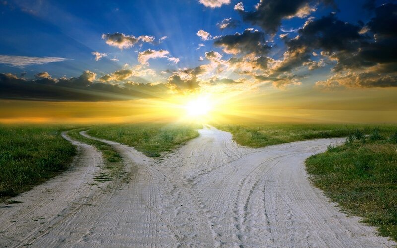 Road at sunset with diverging paths