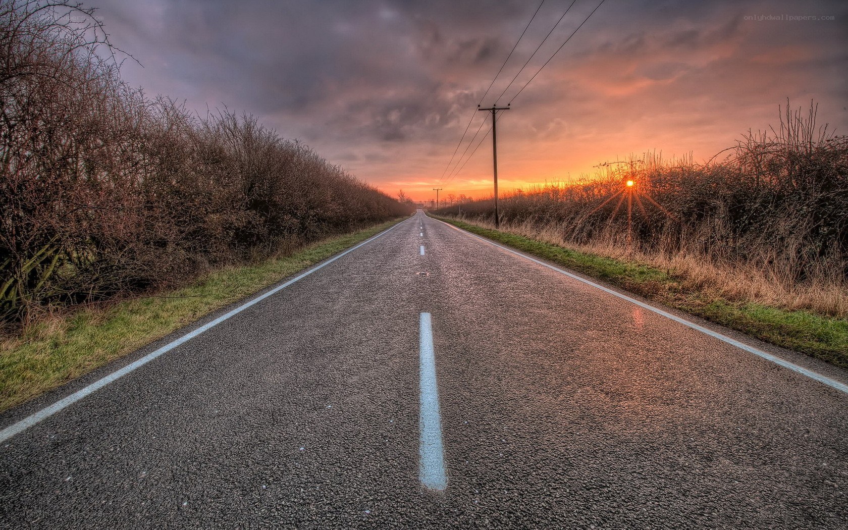 Road at sunset with power lines