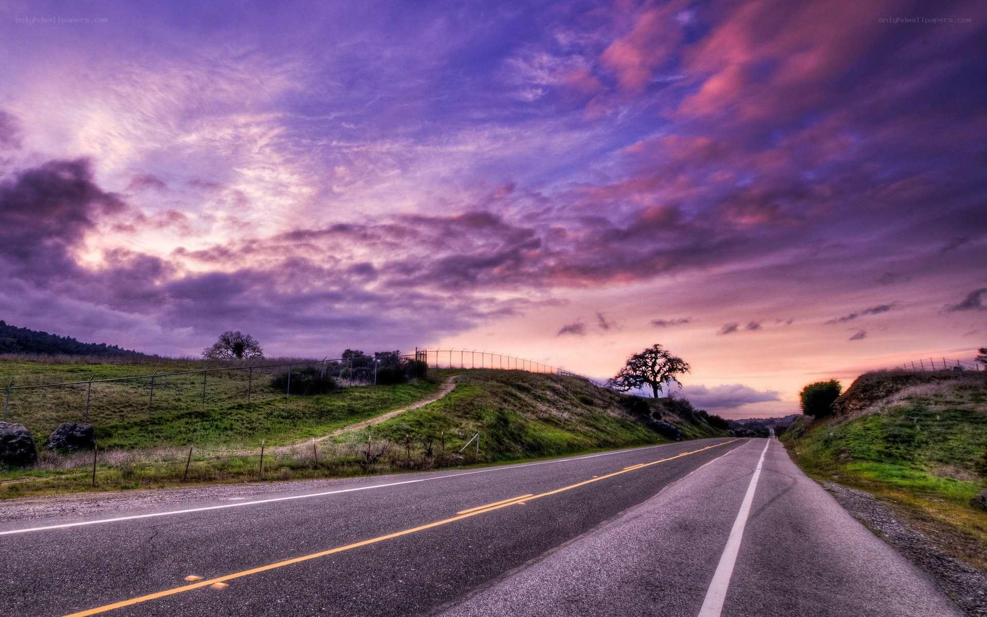 Road at sunset with purple sky