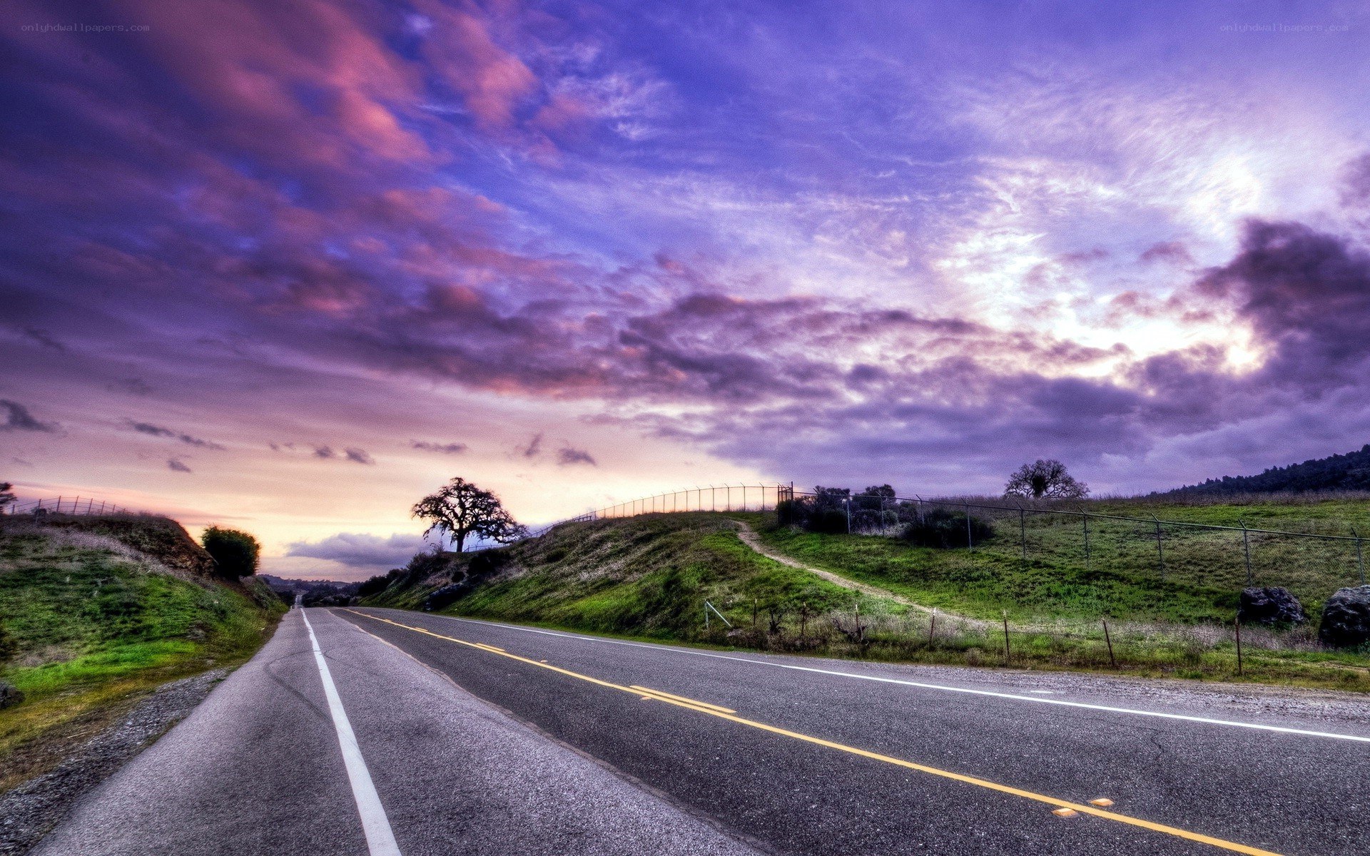 Road at sunset with purple sky