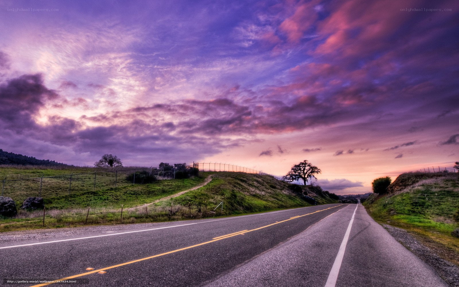 Road at sunset with purple sky