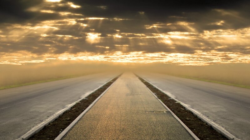 Road at sunset with sunbeams