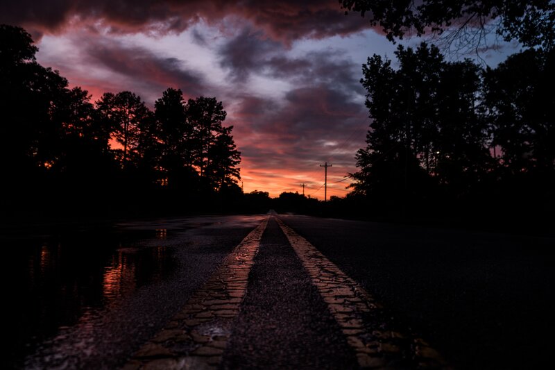 Road at sunset with wet pavement