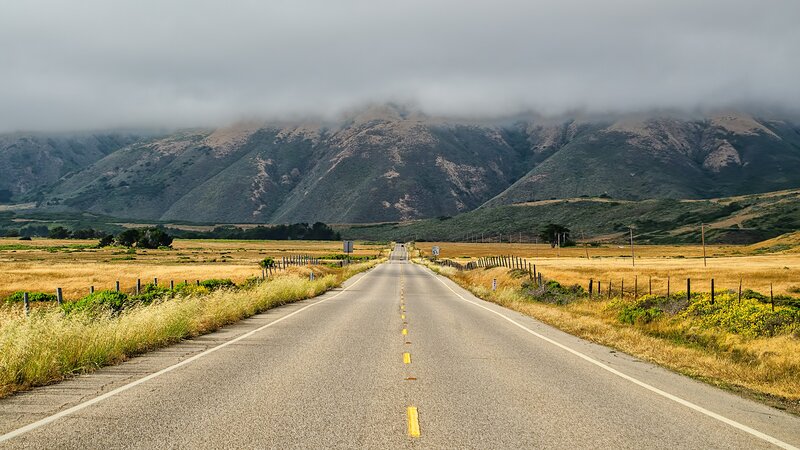 Road leading to foggy mountains