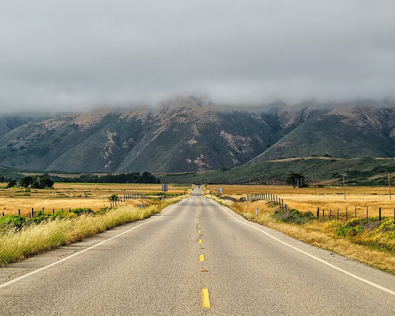 Road leading to foggy mountains