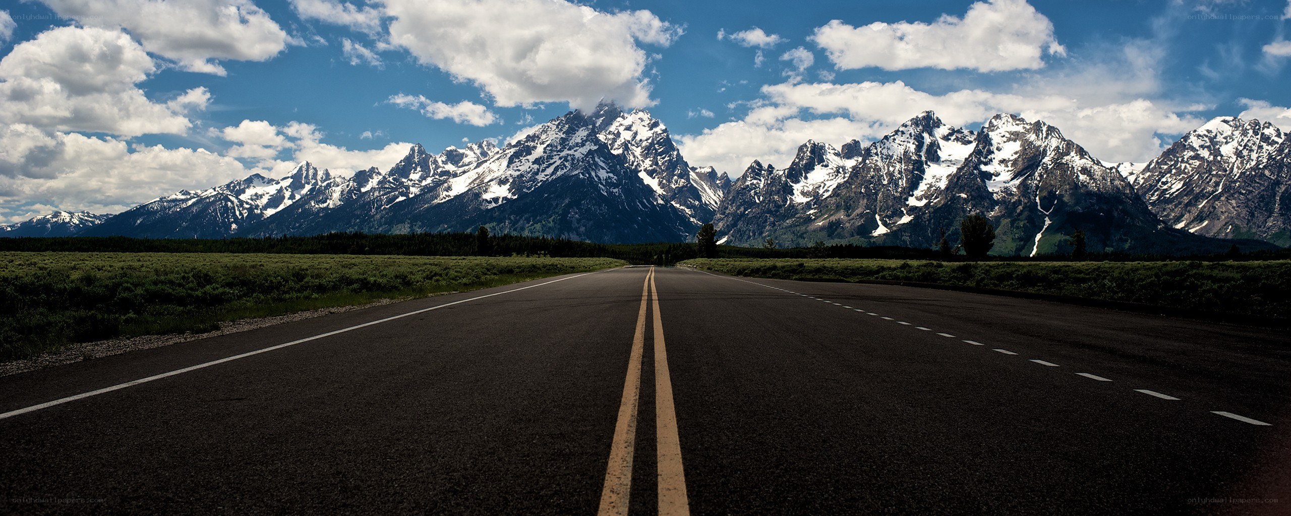 Road leading to snow-capped mountains