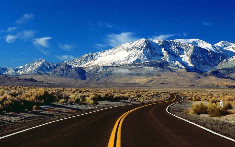 Road leading to snow-capped mountains