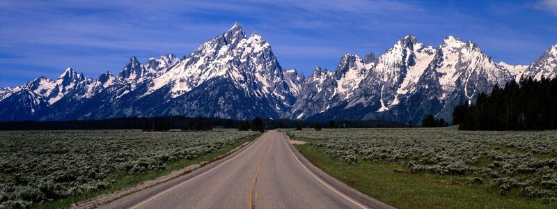 Road leading to snow-capped mountains