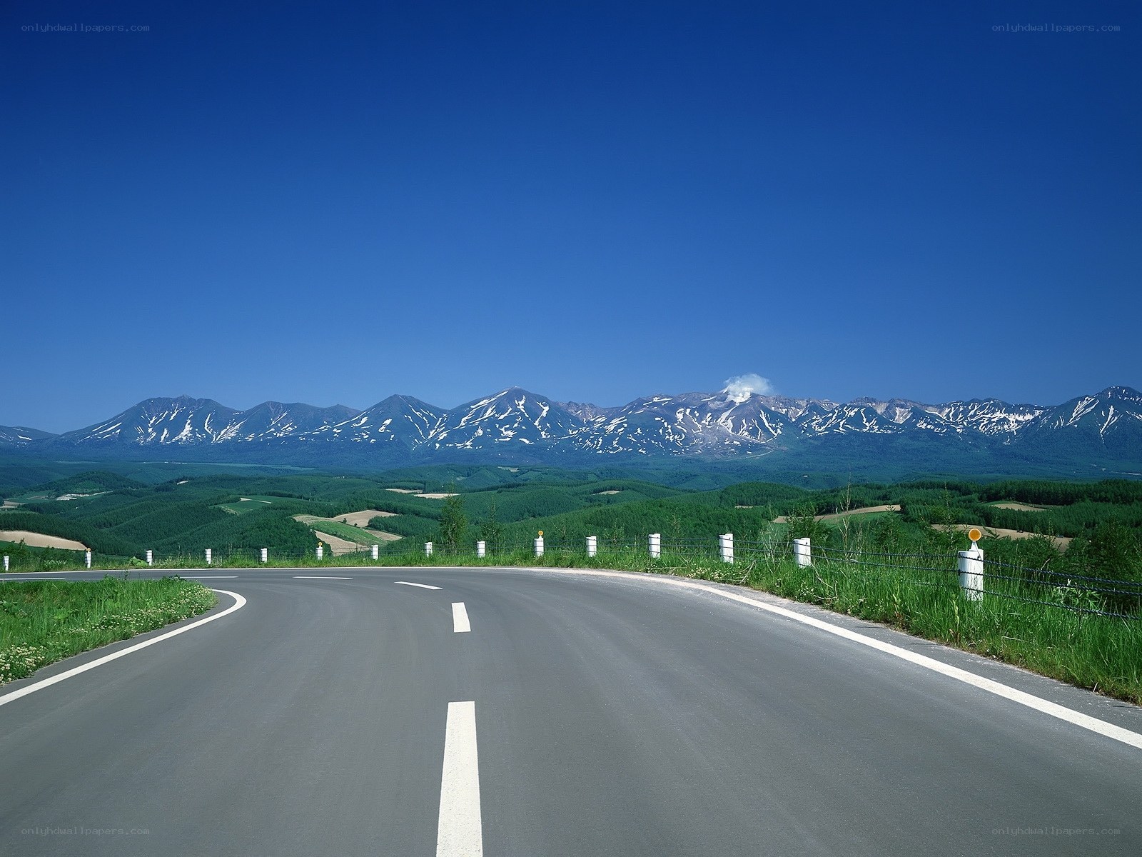 Road leading to snow-capped mountains