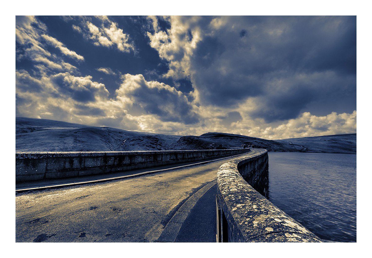 Road on a dam under cloudy sky
