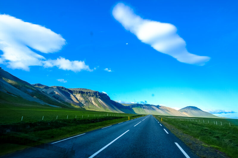 Road through green hills and blue sky