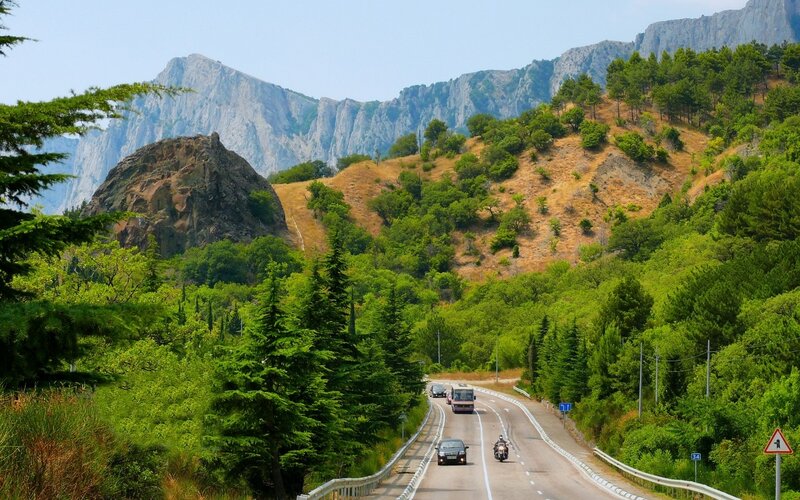 Road Through Mountain Valley — Green, Serene, Afternoon, Photograph, Cars