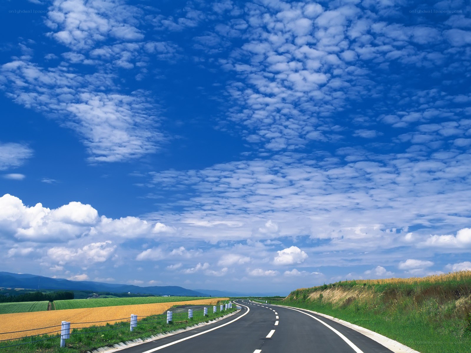 Road under blue sky with clouds