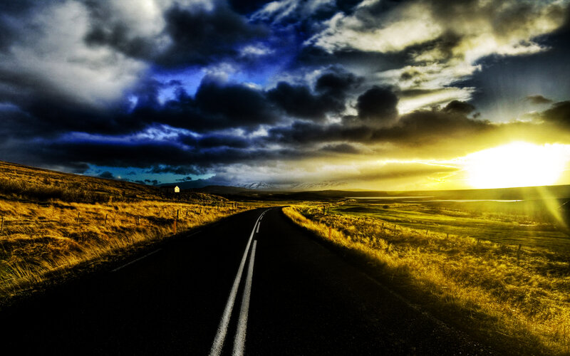 Road under stormy sky at sunset