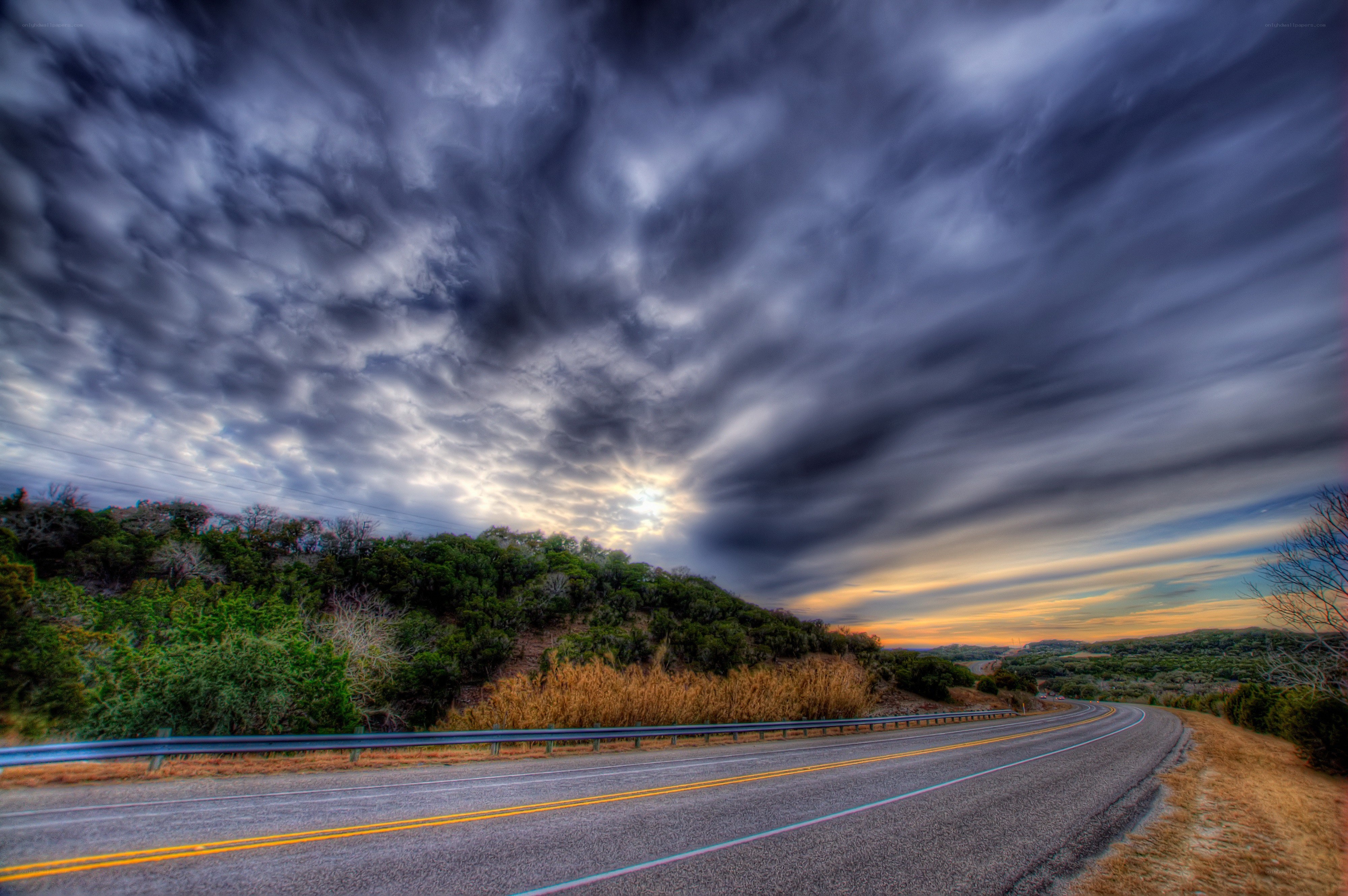 Road under stormy sky at sunset