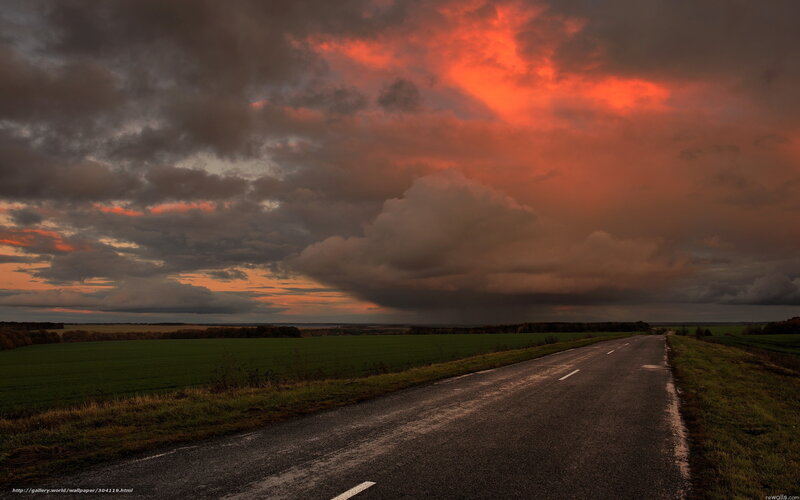 Road under stormy sunset sky