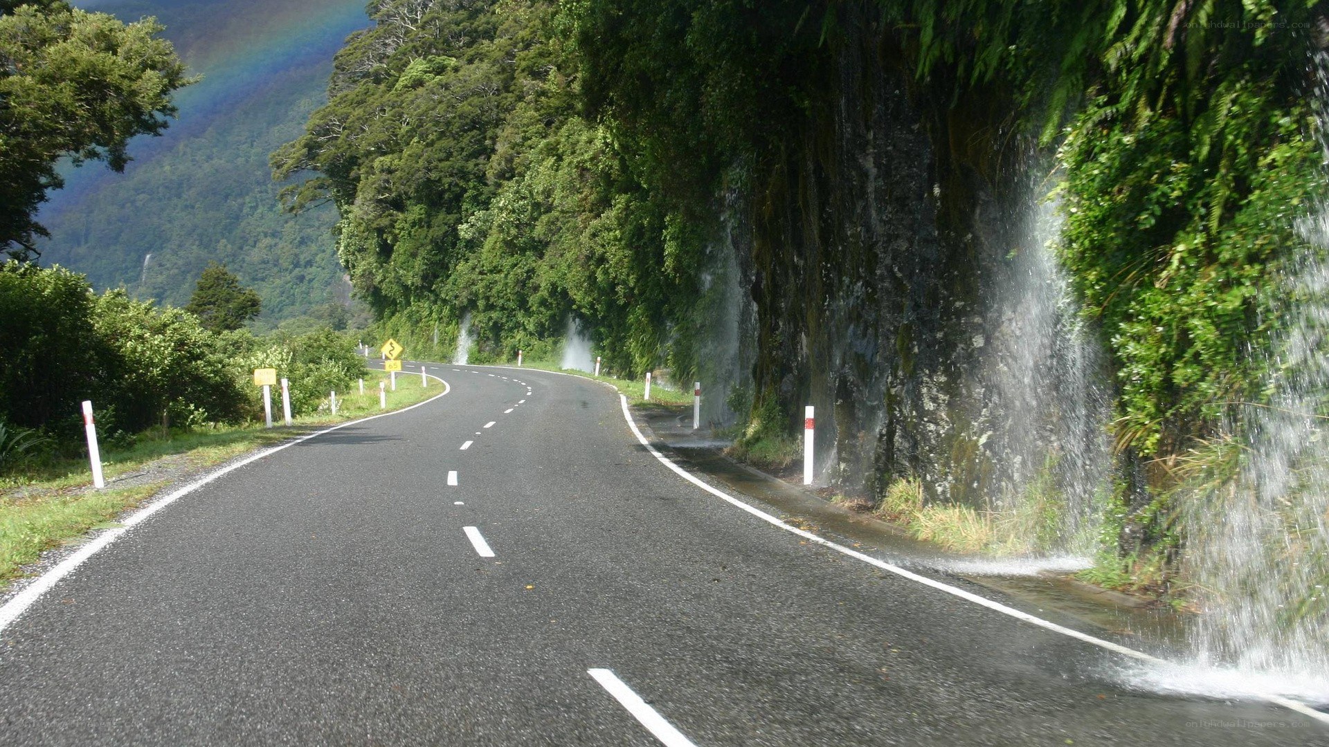 Road with waterfall and rainbow