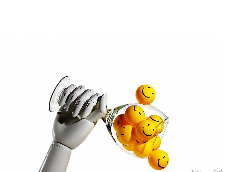 robot hand pouring smiley balls