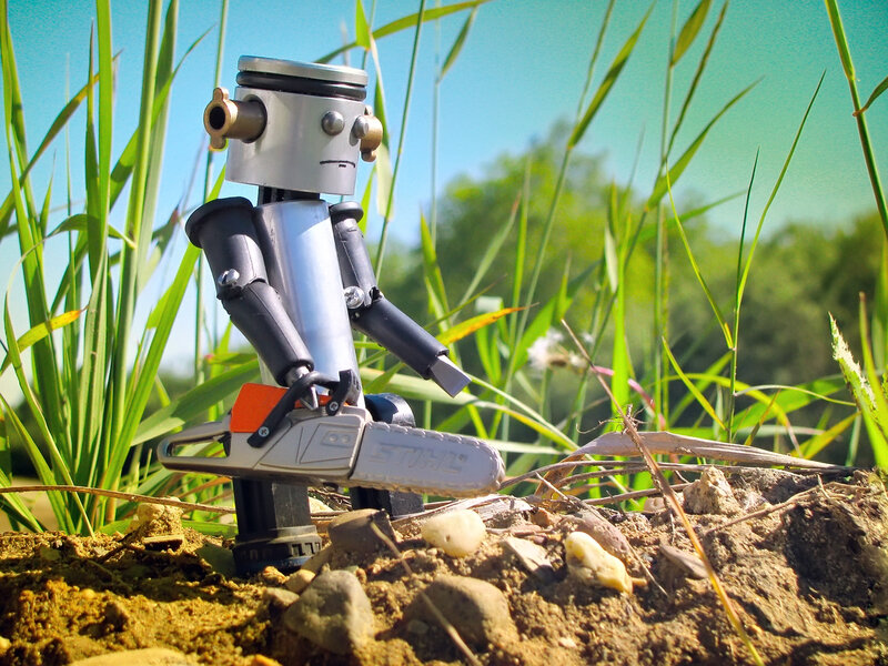 robot with chainsaw in grass