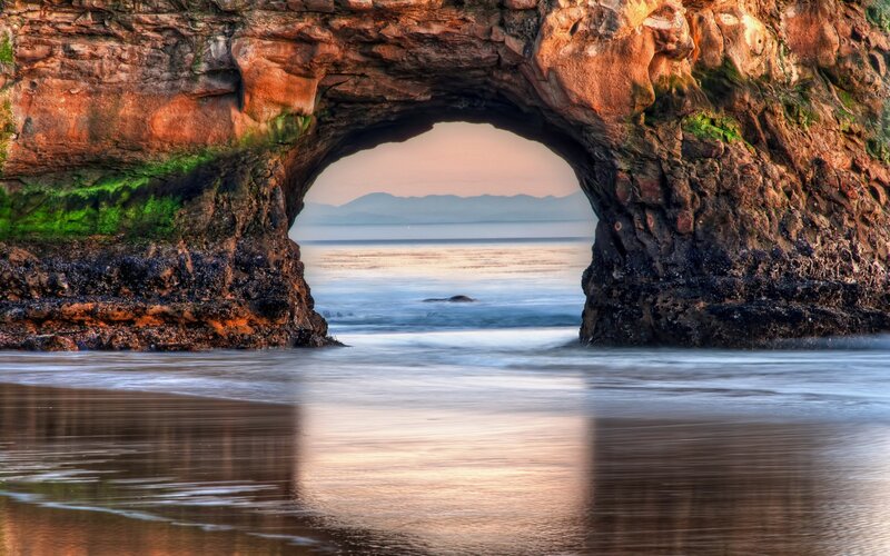 Rock Arch at Beach — Brown, Serene, Sunset, Photograph, Ocean, Mountains