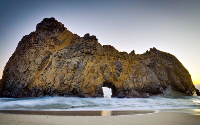 Rock Arch at Beach — Brown, Serene, Sunset, Photograph, Ocean, Sand, Sky