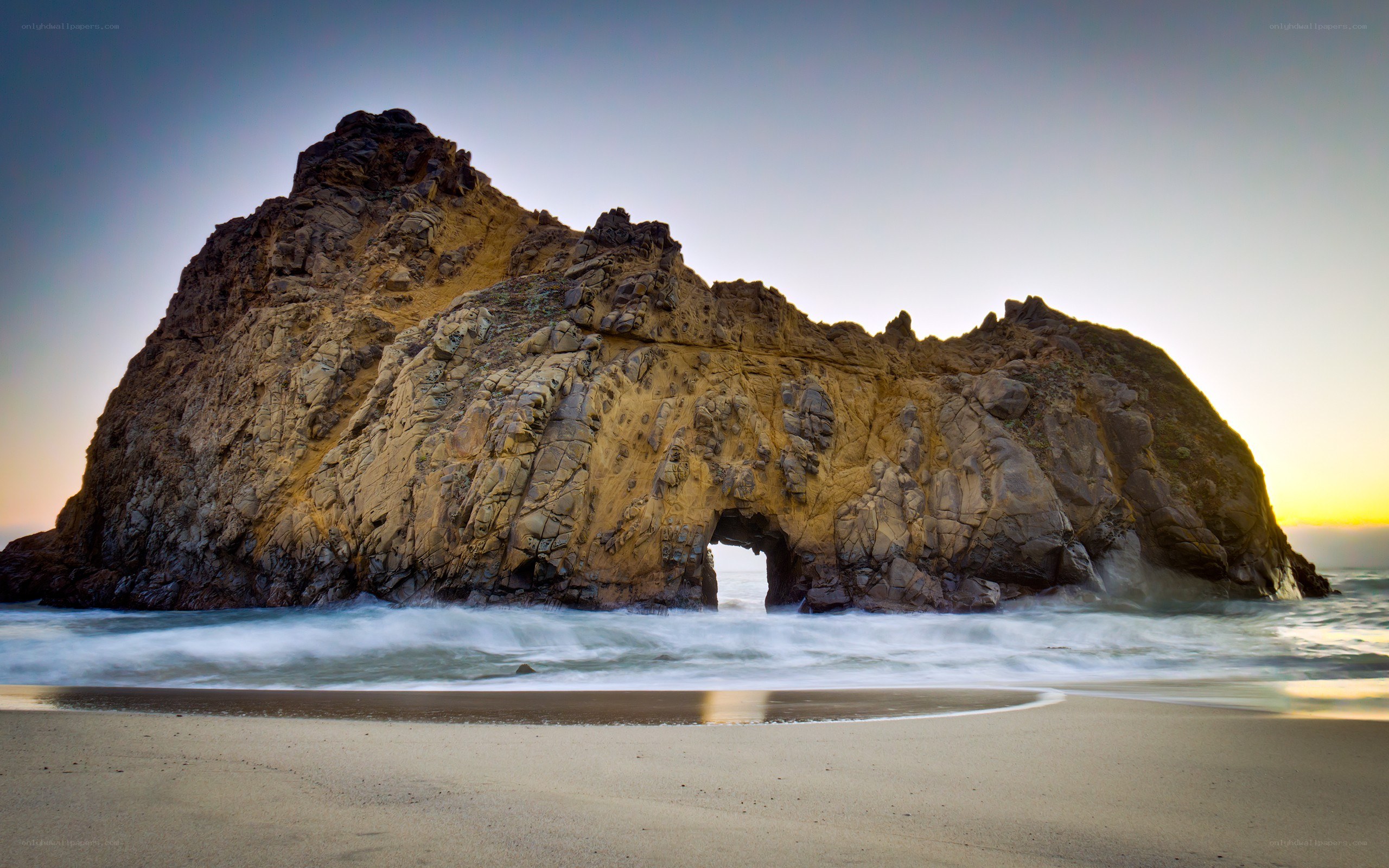 Rock arch at sunset on a beach