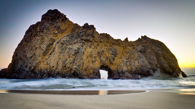 Rock arch at sunset on beach