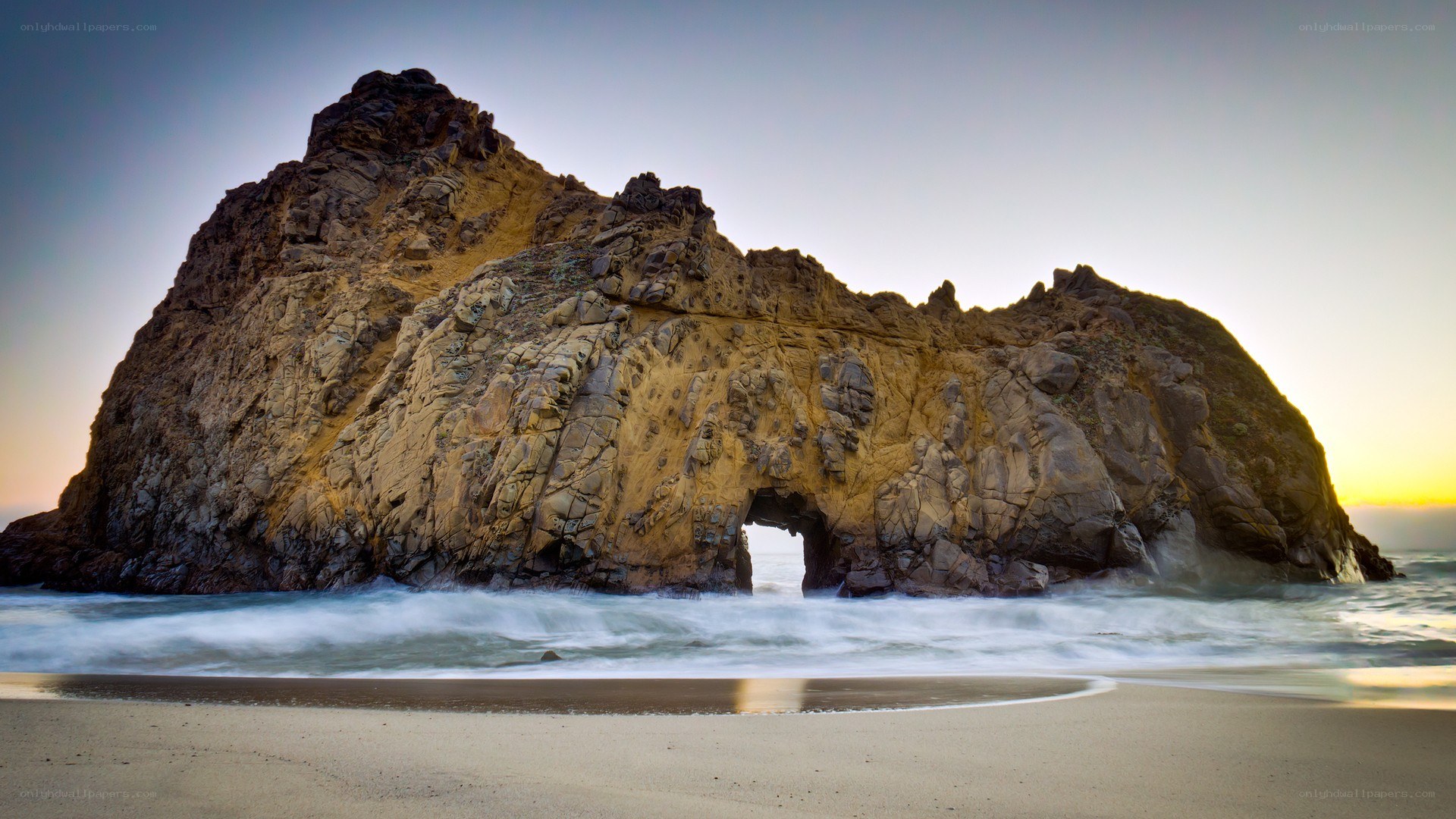 Rock arch at sunset on beach