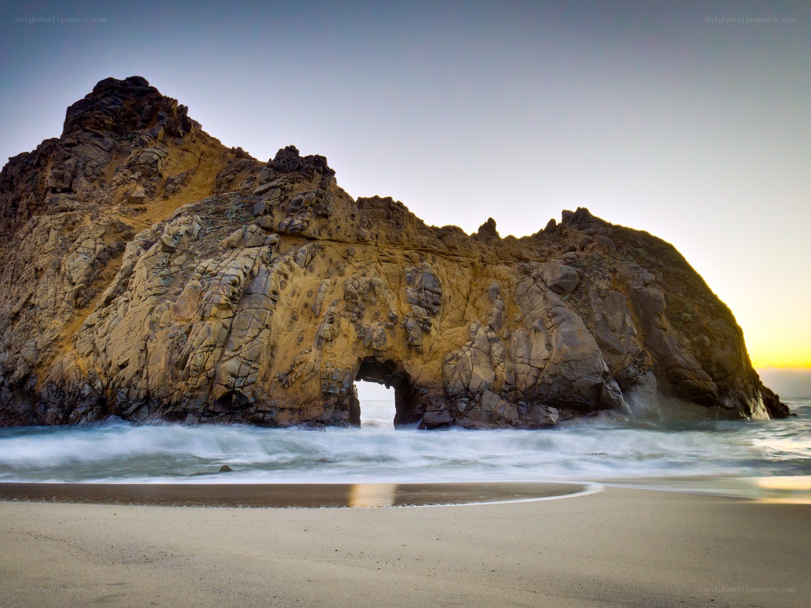 Rock arch at sunset on beach