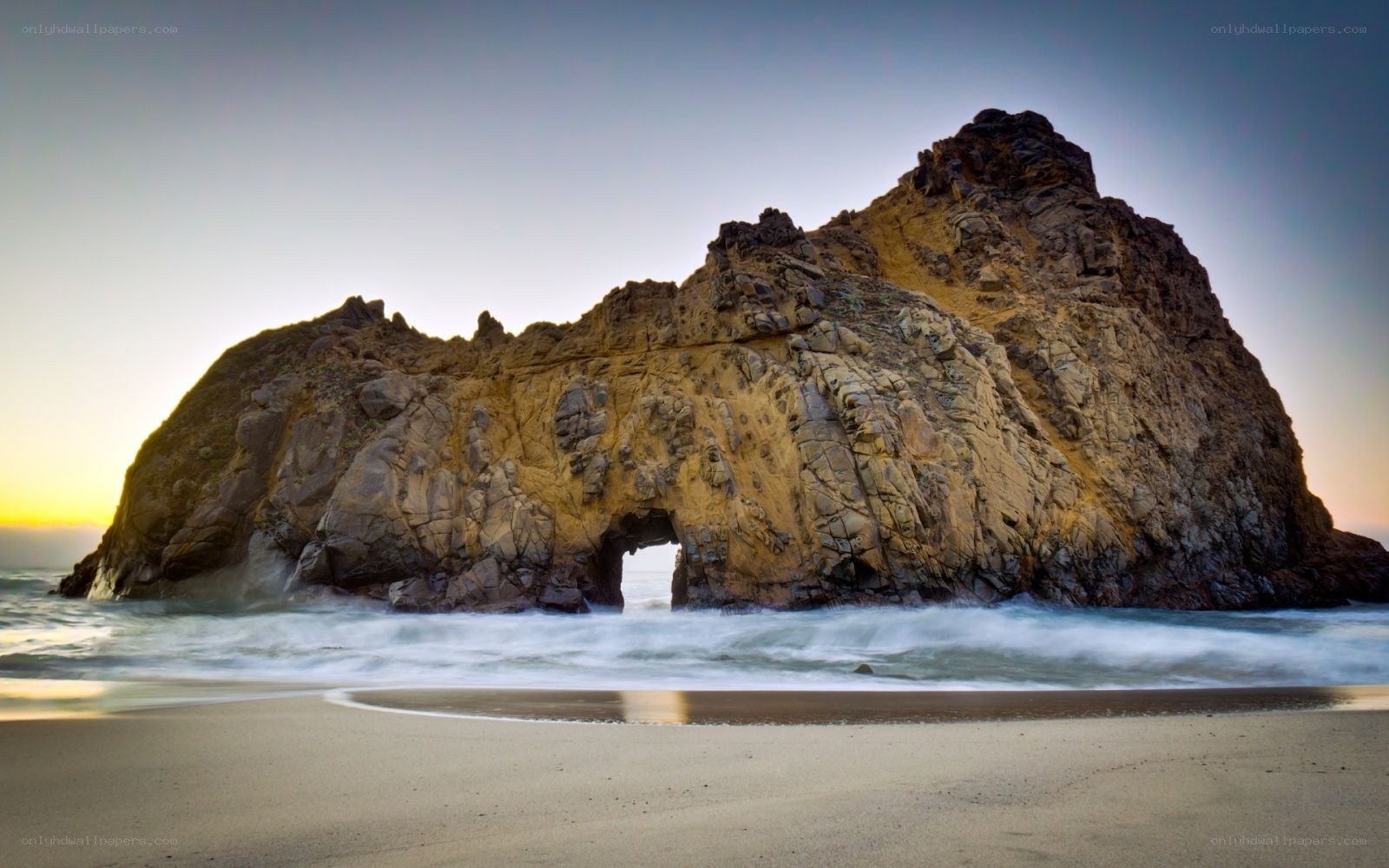 Rock arch at sunset on beach
