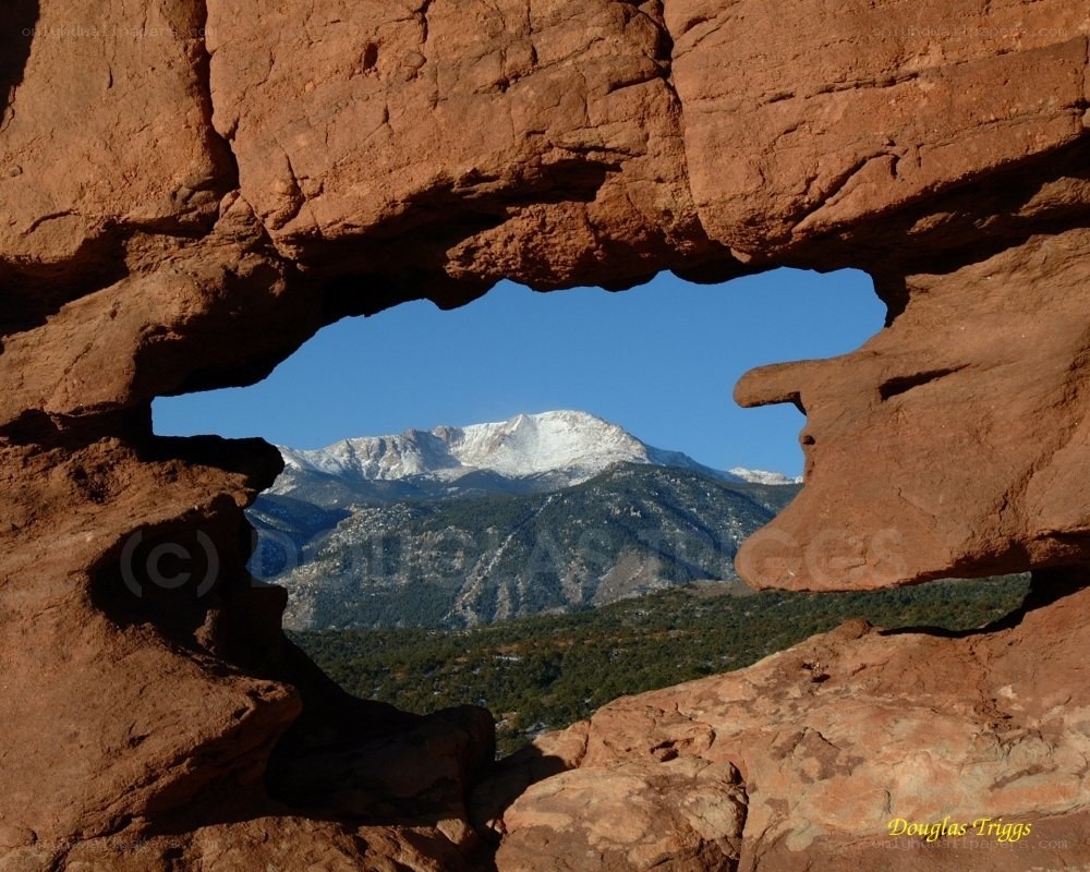 Rock arch framing a snow-capped mountain