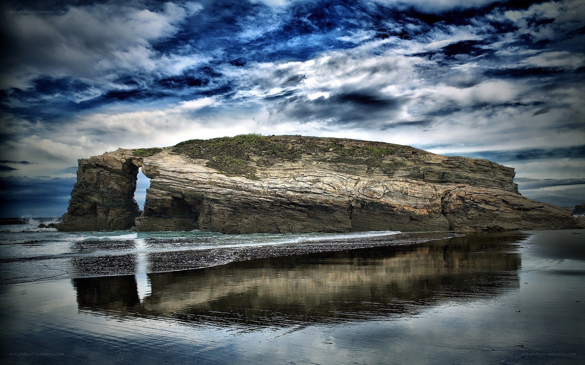 Rock arch on a stormy beach