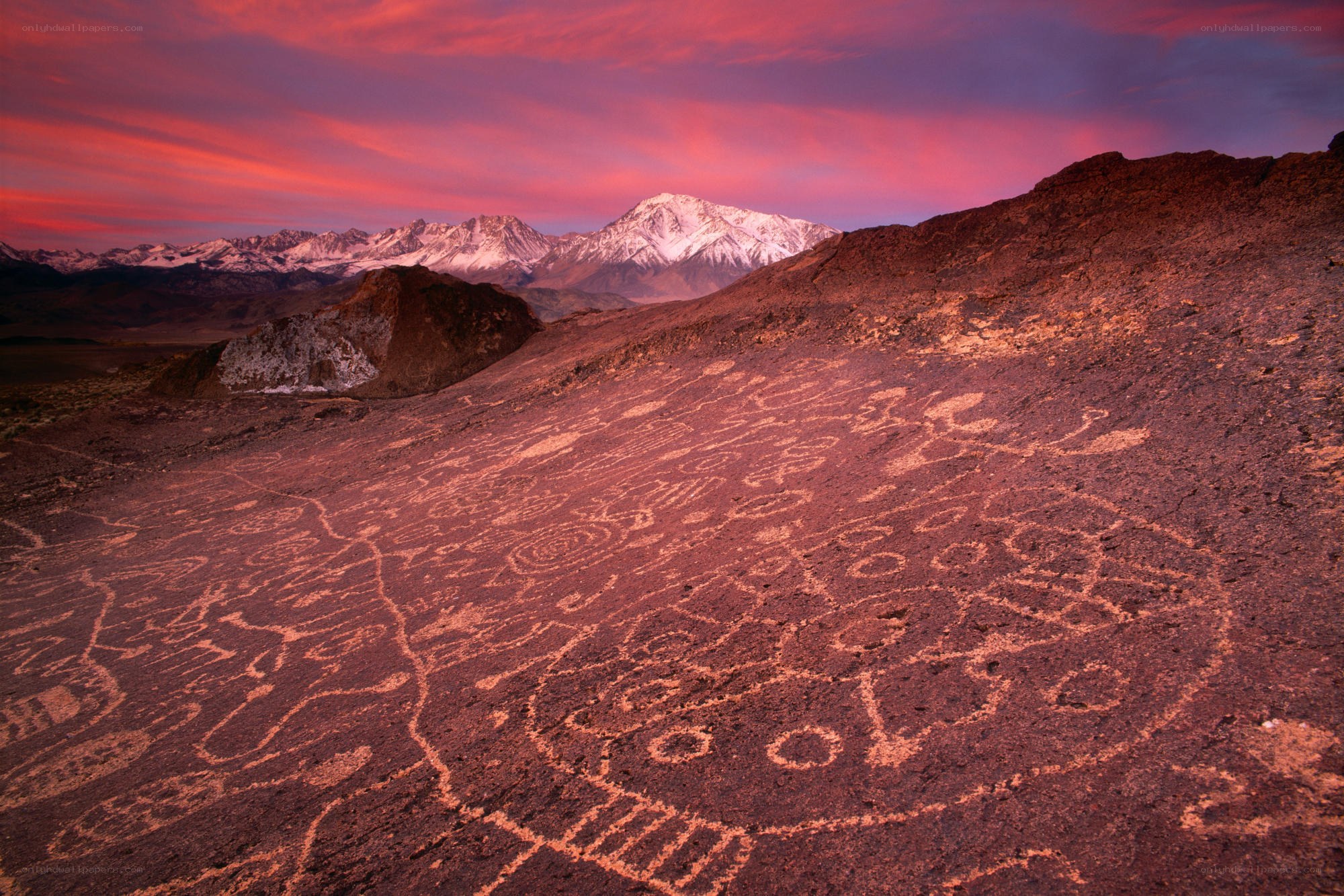 Rock art at sunset with mountains