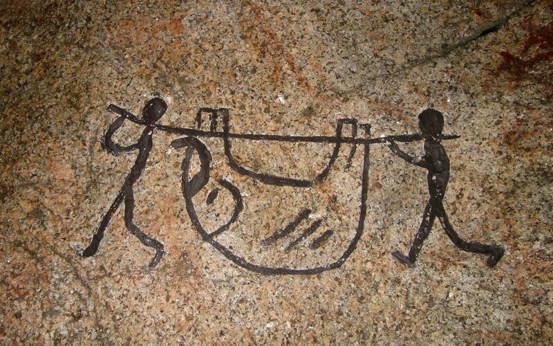 Rock art of two figures carrying a load