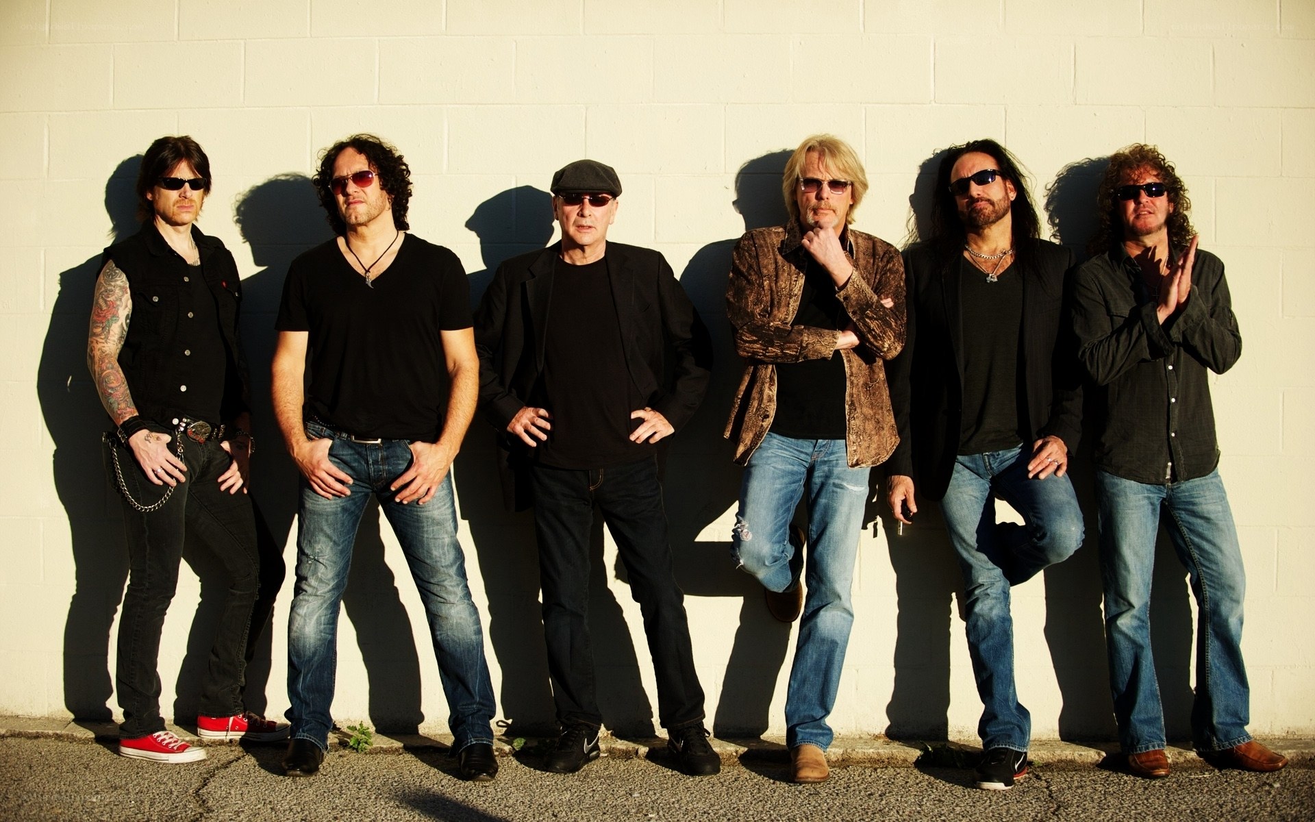 rock band posing against wall