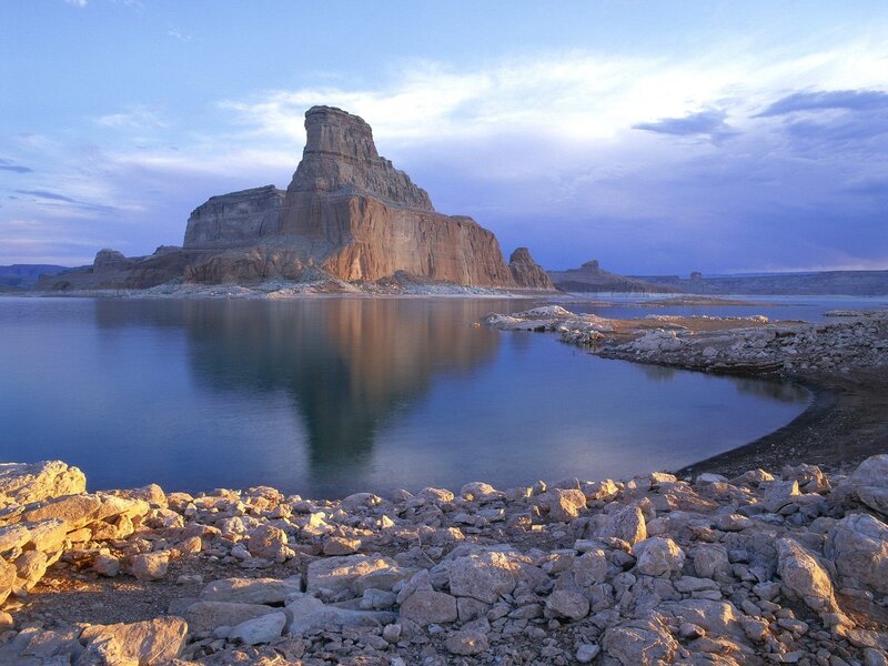 Rock formation by lake at dusk