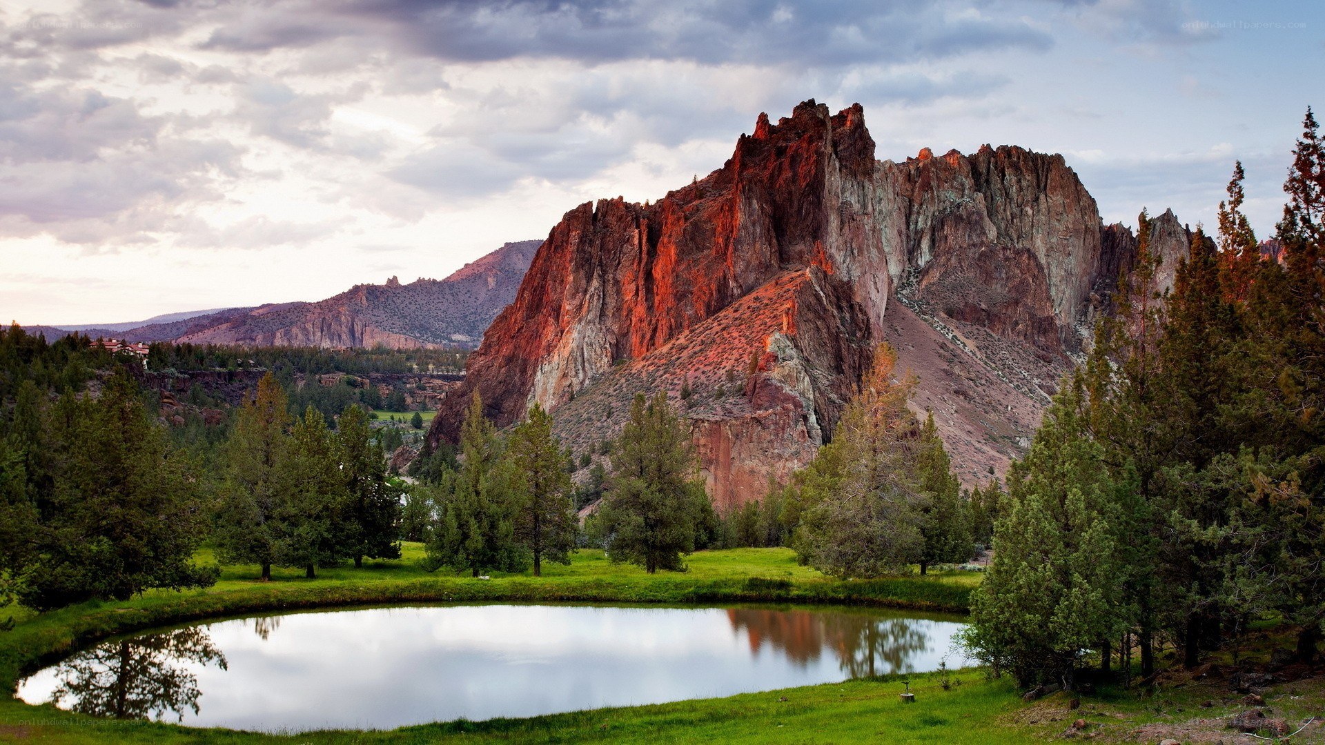 Rock formation by pond at sunset